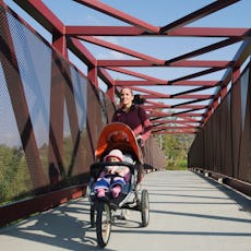 A mom goes on a run with her child in a stroller.