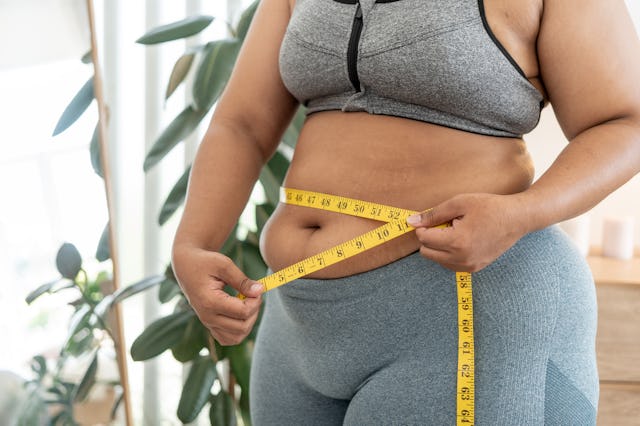 A woman measures her stomach postpartum