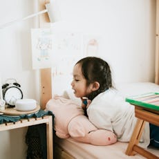 A young girl talks into an AI speaker.