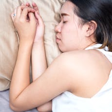 A woman sleeps on a silk pillowcase.