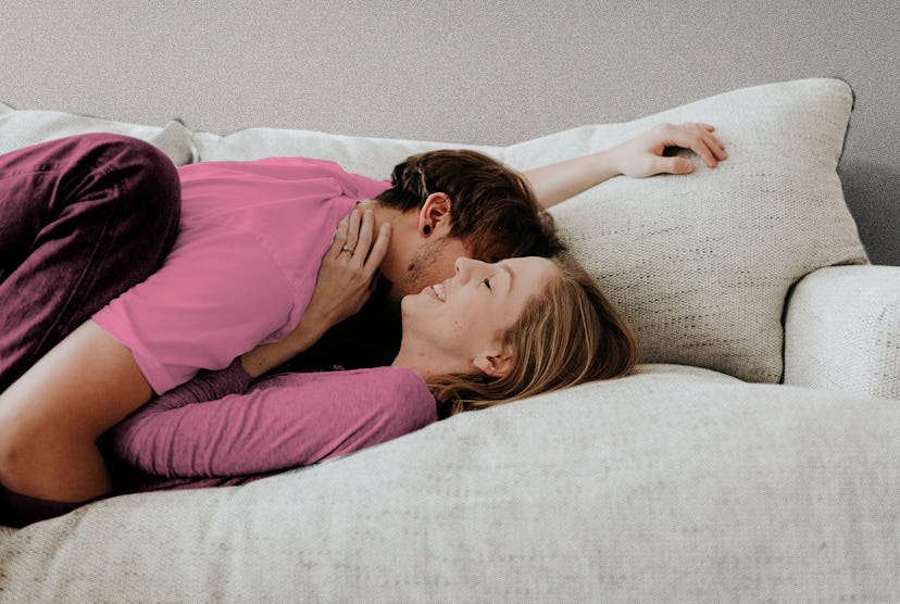 Happy married young couple hugging, sitting on cozy couch together, overjoyed laughing woman and man...