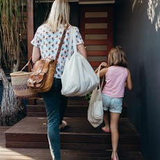 Real life young Australian mum and daughter bring in their groceries in eco shopping bags and basket