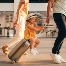 A little girl strolls through the airport with her parents. 