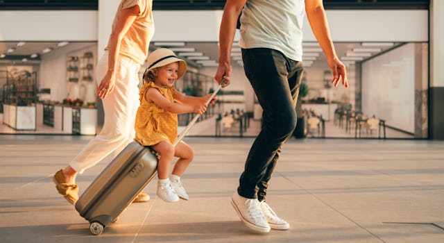 A little girl strolls through the airport with her parents. 