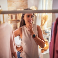 A woman looks in her closet at her capsule wardrobe.