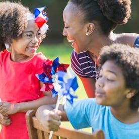 An African American mother with two mixed race children celebrating an American patriotic holiday, p...