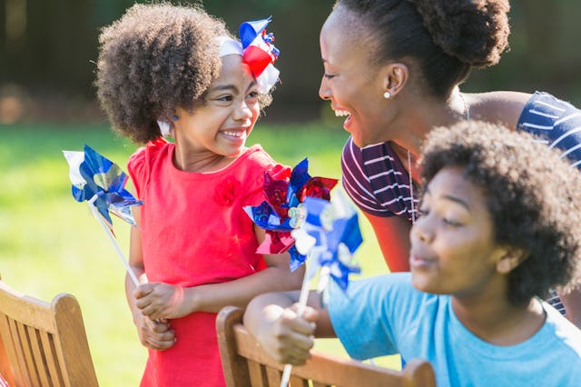 An African American mother with two mixed race children celebrating an American patriotic holiday, p...