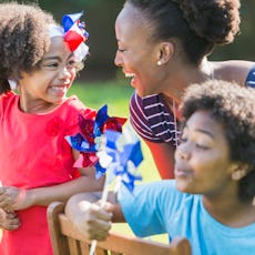 An African American mother with two mixed race children celebrating an American patriotic holiday, p...