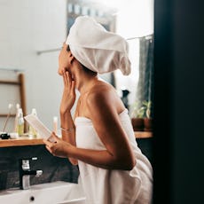 A woman applies self-tanner.