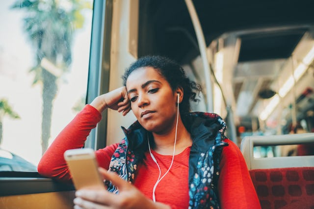 A woman listens to a podcast.