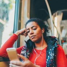 A woman listens to a podcast.