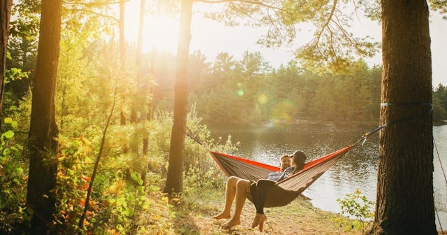 Couple sitting on hammock in the woods