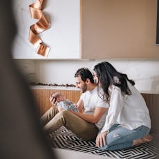 Father and mother holding their newborn baby at home