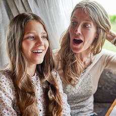 A surprised mother sits with her tween daughter.