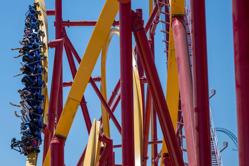 People ride the new Wonder Woman Flight of Courage roller coaster during a press preview of the coas...