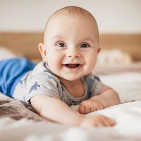 A baby boy smiles into the camera.