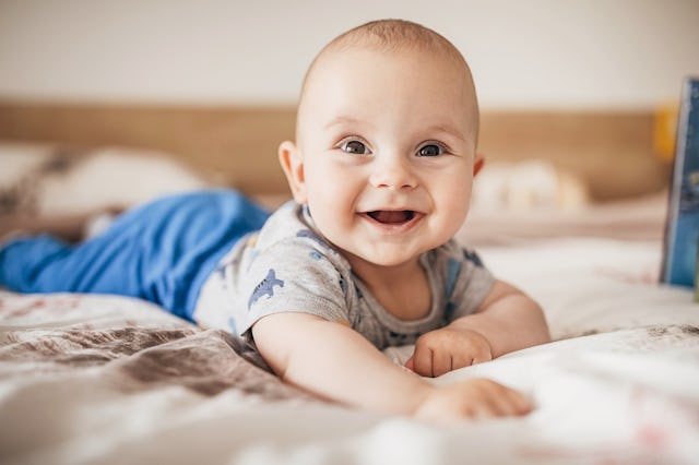 A baby boy smiles into the camera.