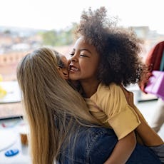 A young girl hugs her mom after being reunited.