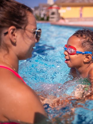 A swim instructor teaches a 3-year-old to swim.