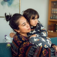 A mom watches TV with her daughter.