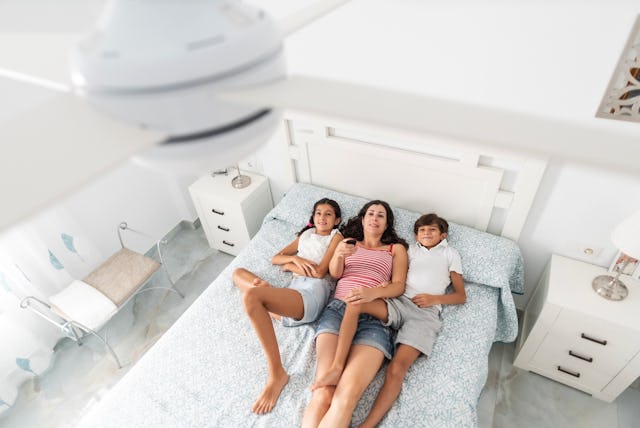 A mom and her kids change the ceiling fan direction.