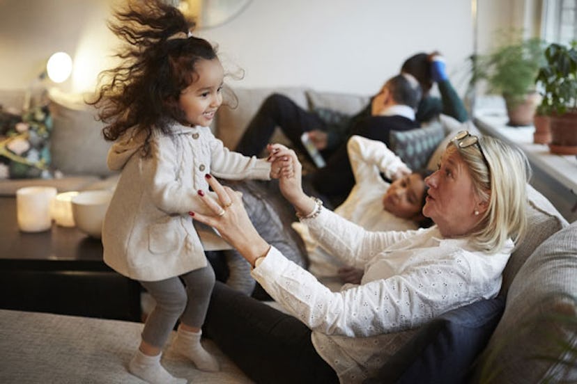 Grandma and a grandchild jumping on a couch.