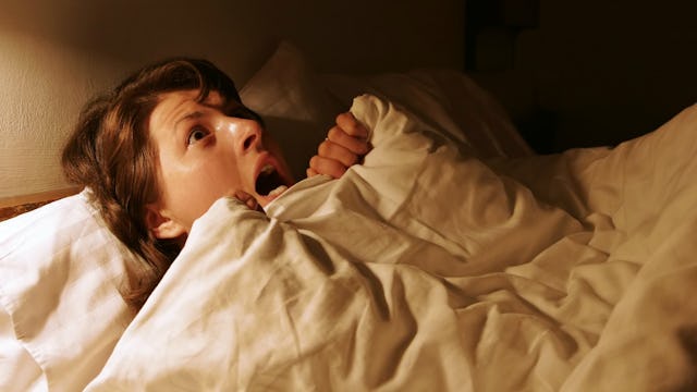 Creeped out mother lying in bed at the nighttime 