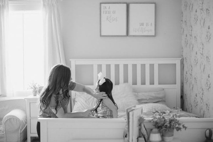 A stay-at-home mom playing with her daughter and making her hairstyle