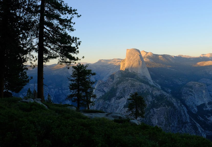 The setting sun casts light and shadow across the face of Half Dome in Yosemite National Park on Aug...