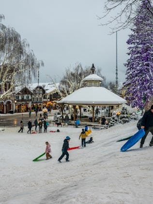 People enjoying a sledding hill in winter in downtown Leavenworth, Washington.